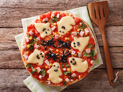 Pizza with ghost shaped cheese cutouts
